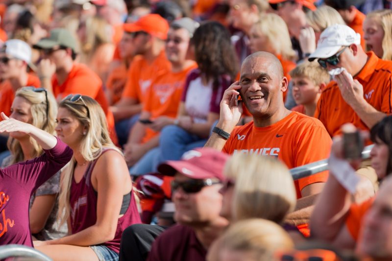person using phone at a football game