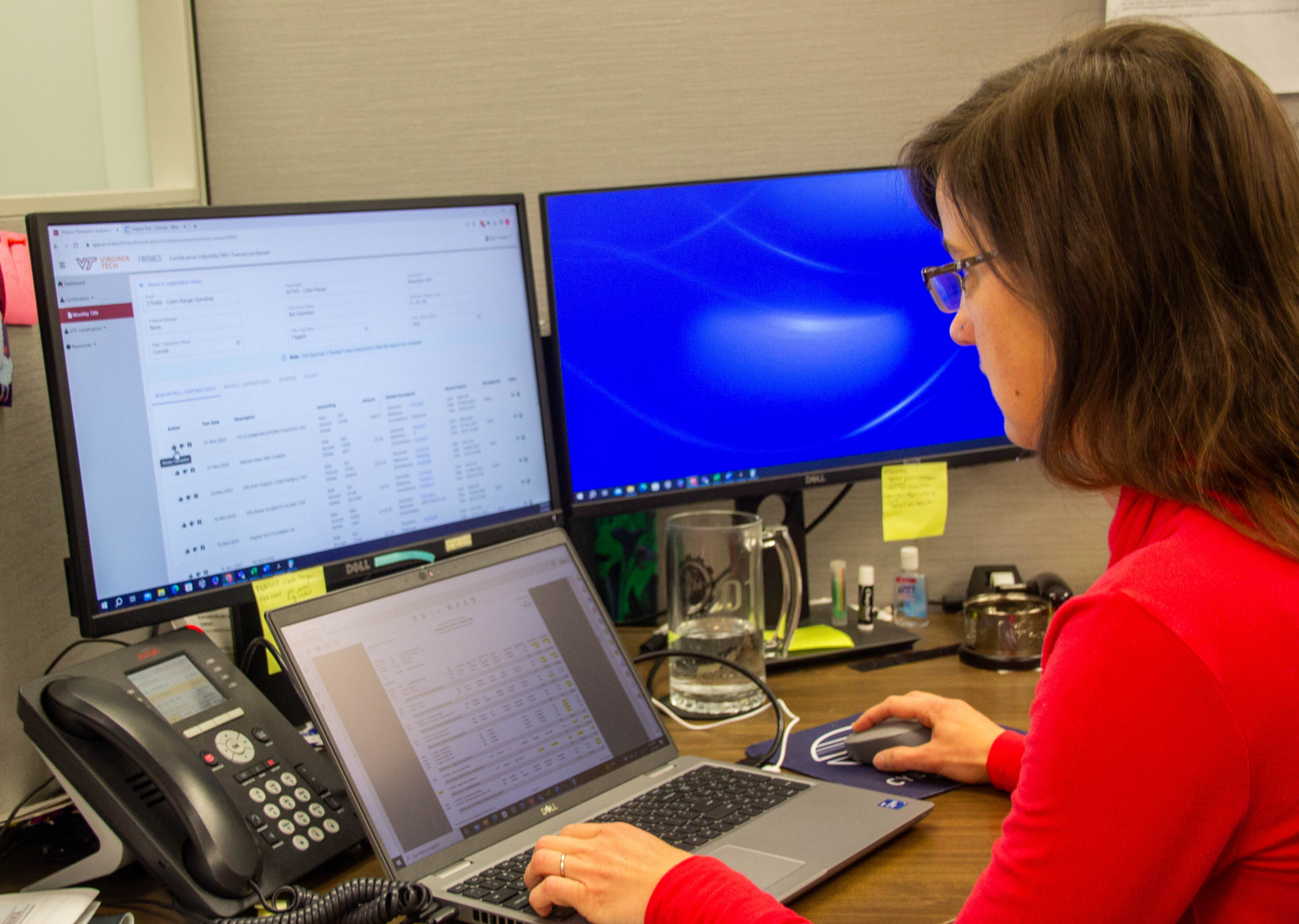 Woman using a computer sitting at a desk.