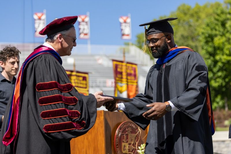 Graduate student receives diploma at commencement ceremony.