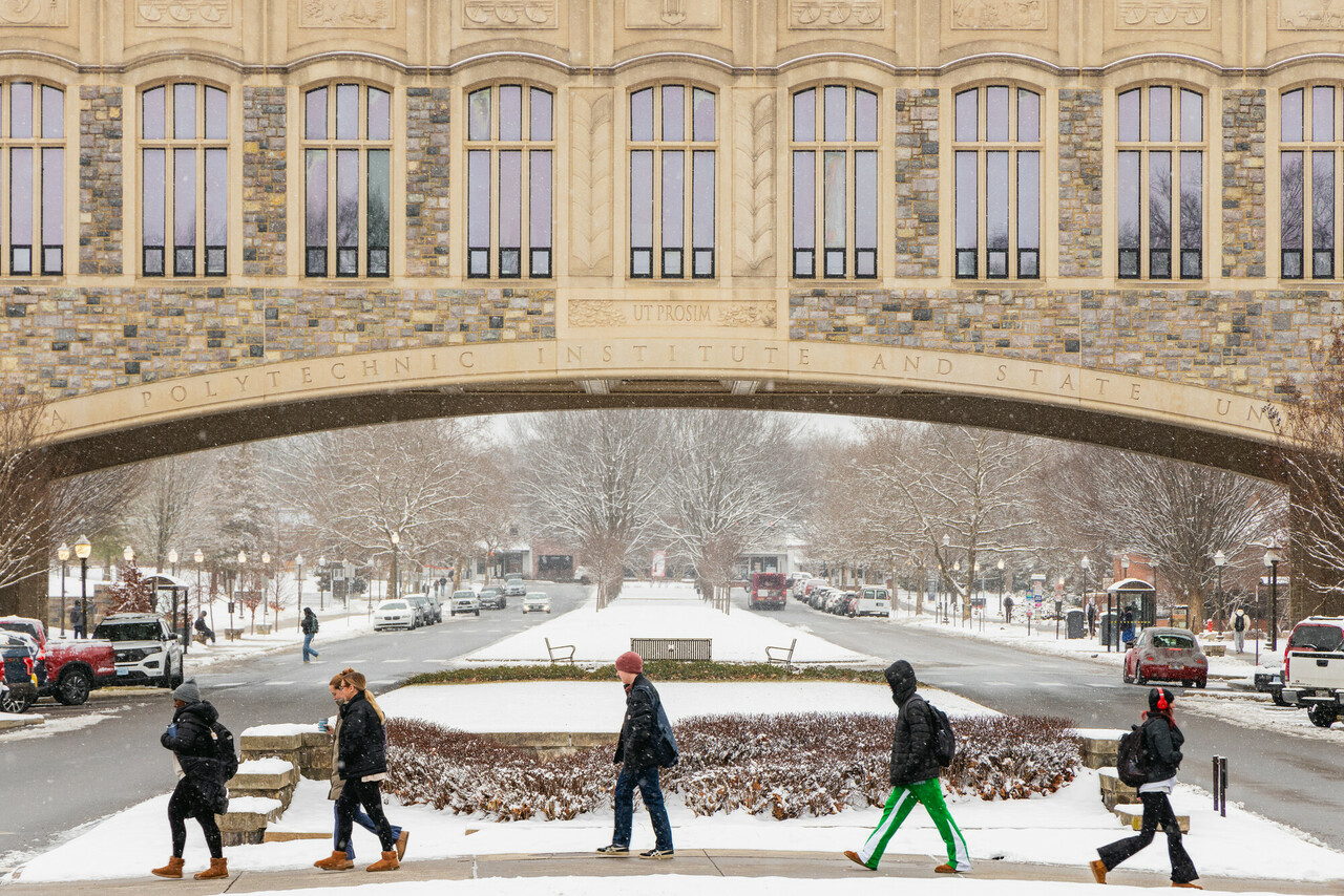 students walking in front of Torgersen Bridge on a snowy day