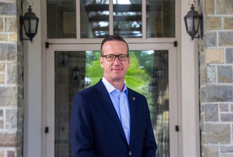 David Raymond, associate vice president for security and identity at Virginia Tech, standing outside in front of a stone building.