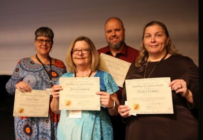 Several recipients of the 2024 Employee Awards & Recognition stand together holding their certificates and smiling for a group photo.