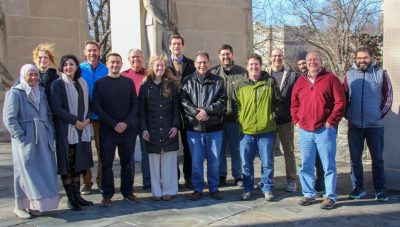 Group photo of the Advanced Research Computing team taken in December 2024, with members standing outdoors in front of the Pylons on a sunny winter day.