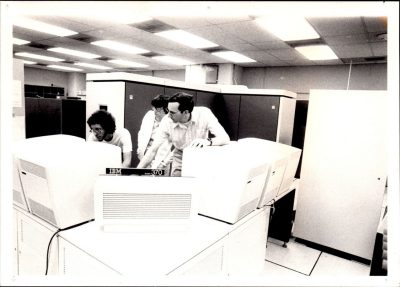 (L to R) Randy Marchancy, Christine Morrison, and Marshall Fisher work on an IBM 370  mainframe, ca. 1980.