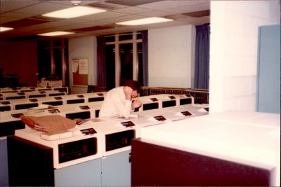 Jerry Bell reads while working night shift at Burruss Hall computing center, ca. 1979.