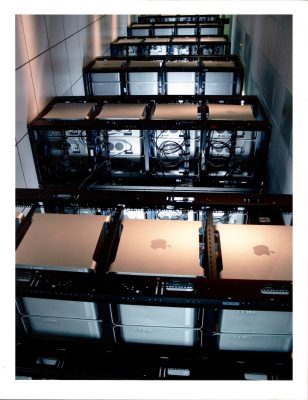 rows of apple computers in a dark room