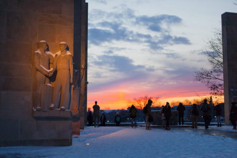 statue of two men shaking hands at sunset on snowy evening