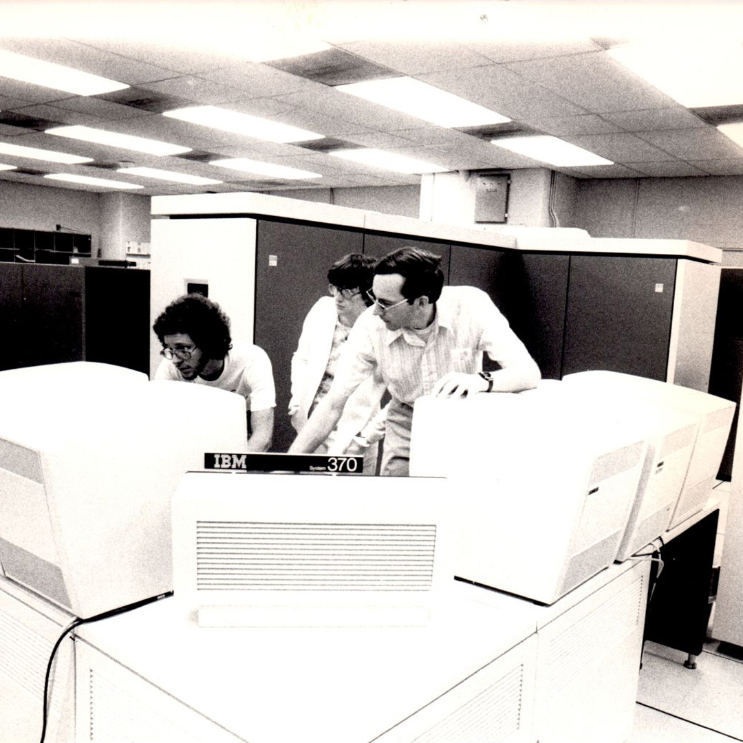 (L to R) Randy Marchancy, Christine Morrison, and Marshall Fisher work on an IBM 370  mainframe, ca. 1980.