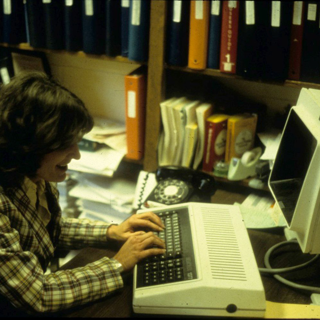 Woman (Rosie Higdon) typing on a old computer.